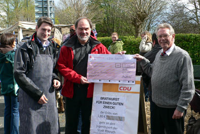 CDU-Landtagskandidat Holger Mller (rechts) und Stadtverbandsvorsitzender Uwe Pakendorf (links) bergeben den Erls aus dem Bratwurstverkauf an Wilfried Lingenberg, Vorsitzender des SV Union Rsrath (Mitte).